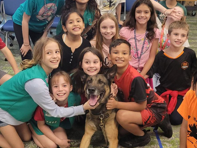 classroom photo of children loving a K-9 Police dog